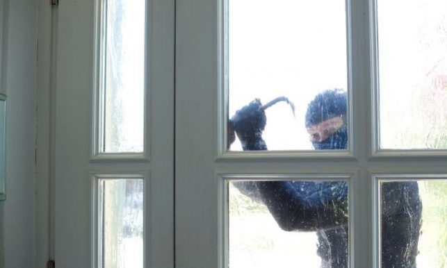 photo voleur blog sécuriser son habitation Cambrioleur qui essaie d'ouvrir une fenêtre avec un pied-de-biche