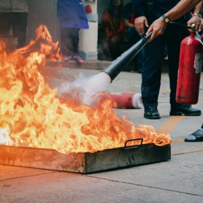 Personne qui éteint un feu avec un extincteur