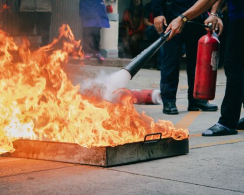 Personne qui éteint un feu avec un extincteur